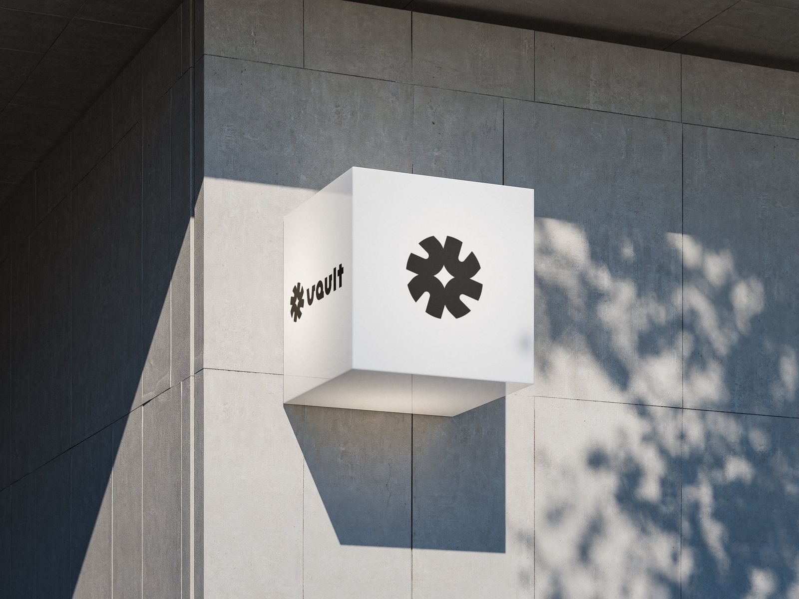 White cube wall sign on concrete building showing black Vault asterisk mark and wordmark